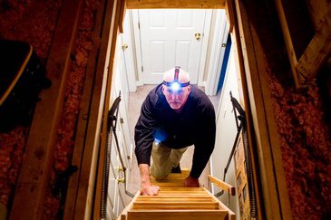 A man standing on a staircase with a flashlight.